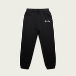 Black sweatpants with a Normform logo on a beige background