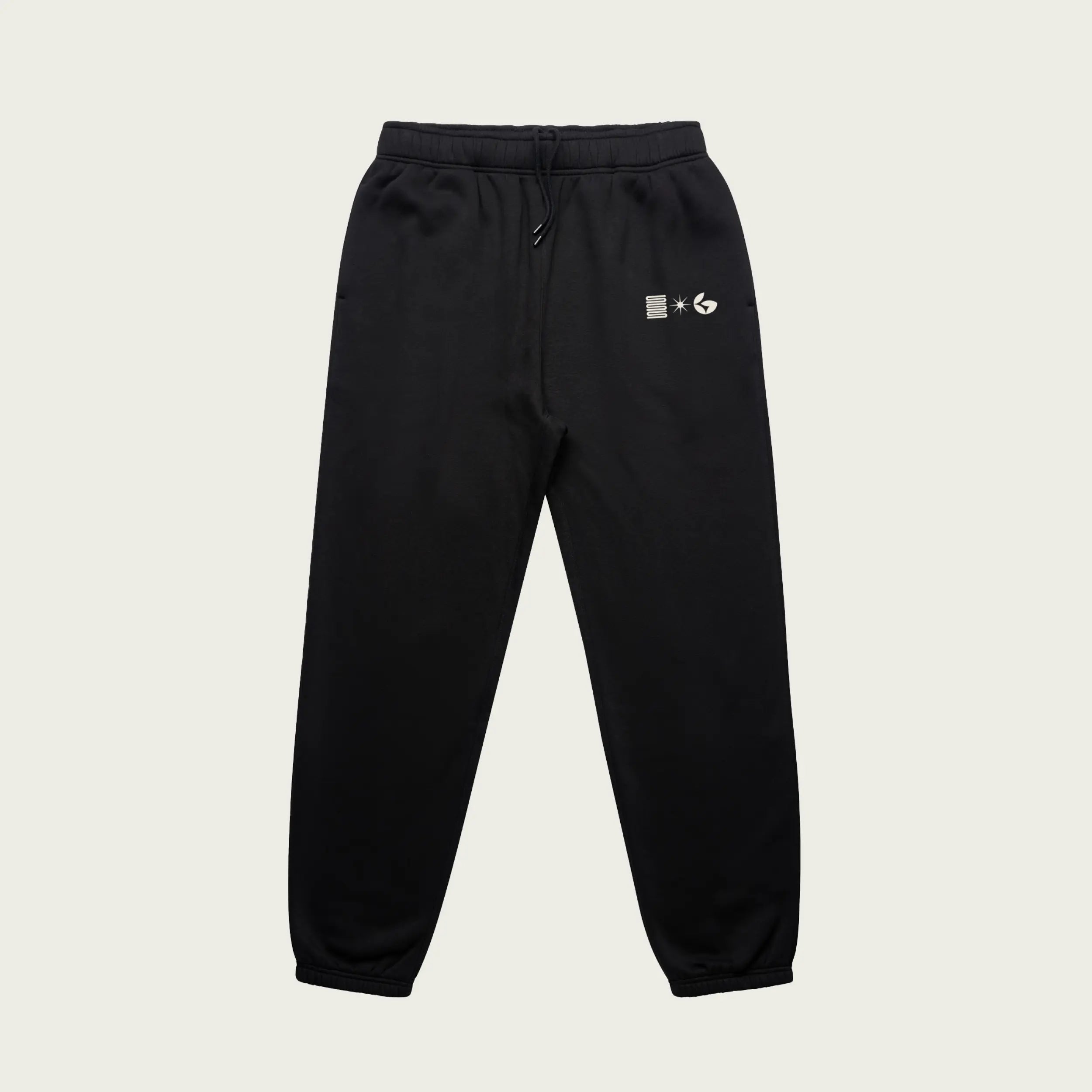 Black sweatpants with a Normform logo on a beige background