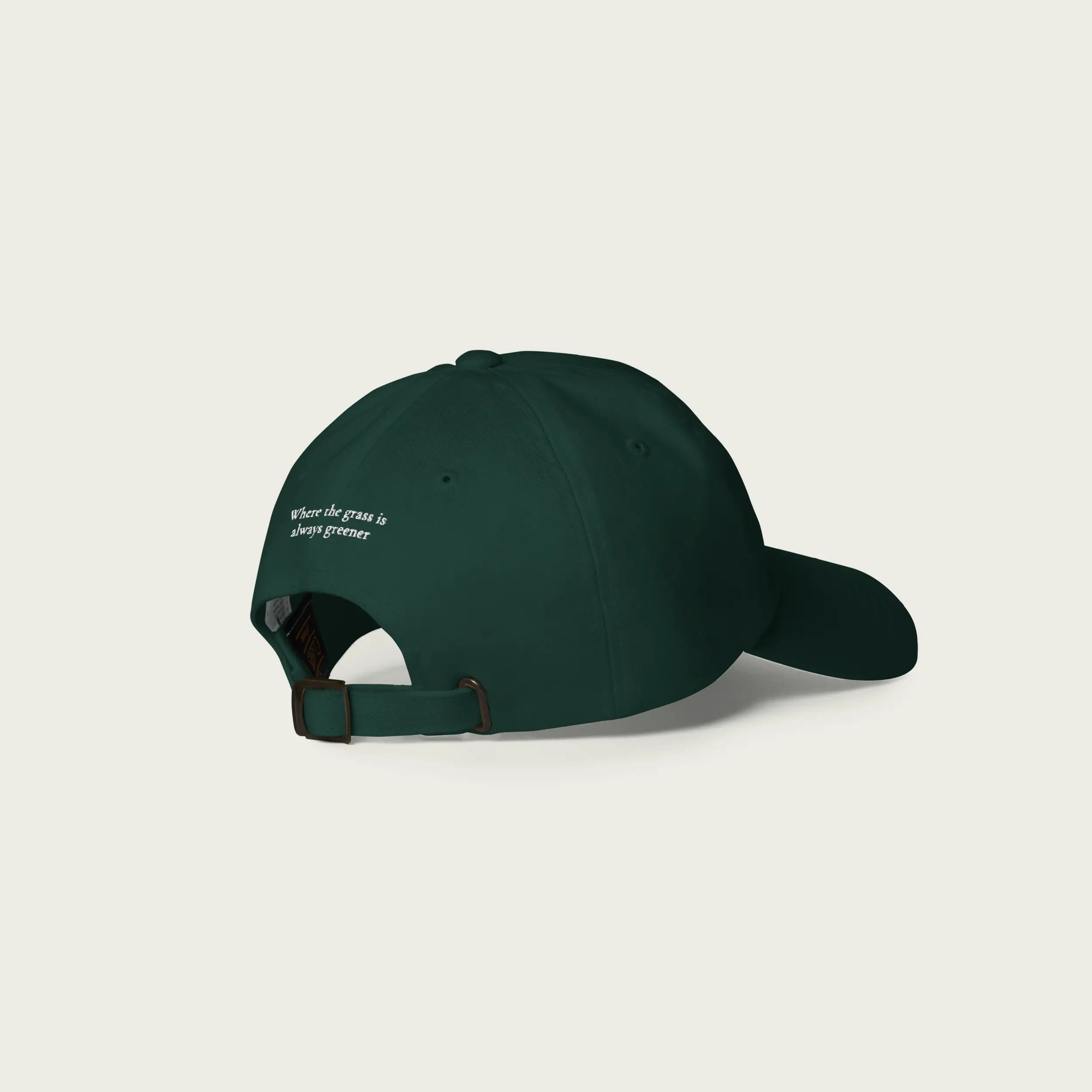 Back view of green Session Goods Rolling Garros dad hat with embroidered text reading ‘Where the grass is always greener.’
