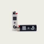 Pair of Normform B&W lighters from Session Goods, showing the black and white custom designs with minimalist graphics in a close-up product shot.