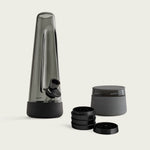 The Session Goods Starter Bundle, featuring a designer ash-colored glass bong with a black silicone base and downstem, a black metal grinder, and a  stash jar with a silicone smell proof lid, all set against a clean white background.