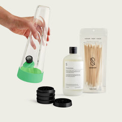 Session Goods Bong Starter Bundle in Glow Lime Green, including a glass water pipe, black grinder, cleaning solution, and cotton swabs.