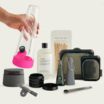 A complete Session Goods Ultimate Bundle featuring a clear glass bong with Magenta Pink silicone accents, a matching hand pipe, a black precision grinder, a stash jar, and a full cleaning kit with specialized solution and a silicone pouch.