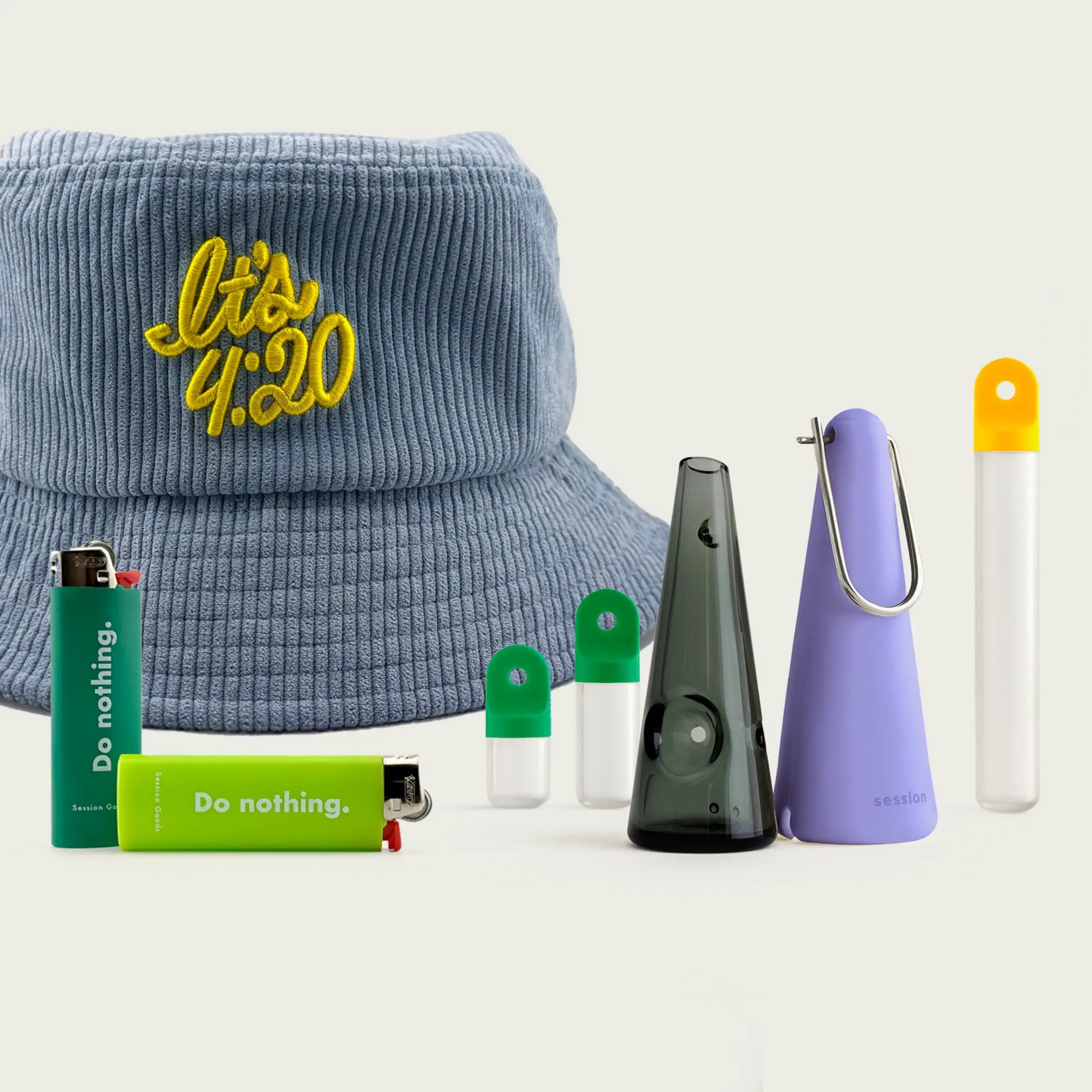 Session Goods Back to School Bundle featuring a faded blue corduroy bucket hat embroidered with ‘It’s 4:20’ in yellow, a translucent one-hitter pipe with a purple cone sleeve, two green-capped stash pods, green and lime ‘Do nothing.’ branded lighters, and a clear stash tube with a yellow cap — all set against a soft neutral background.