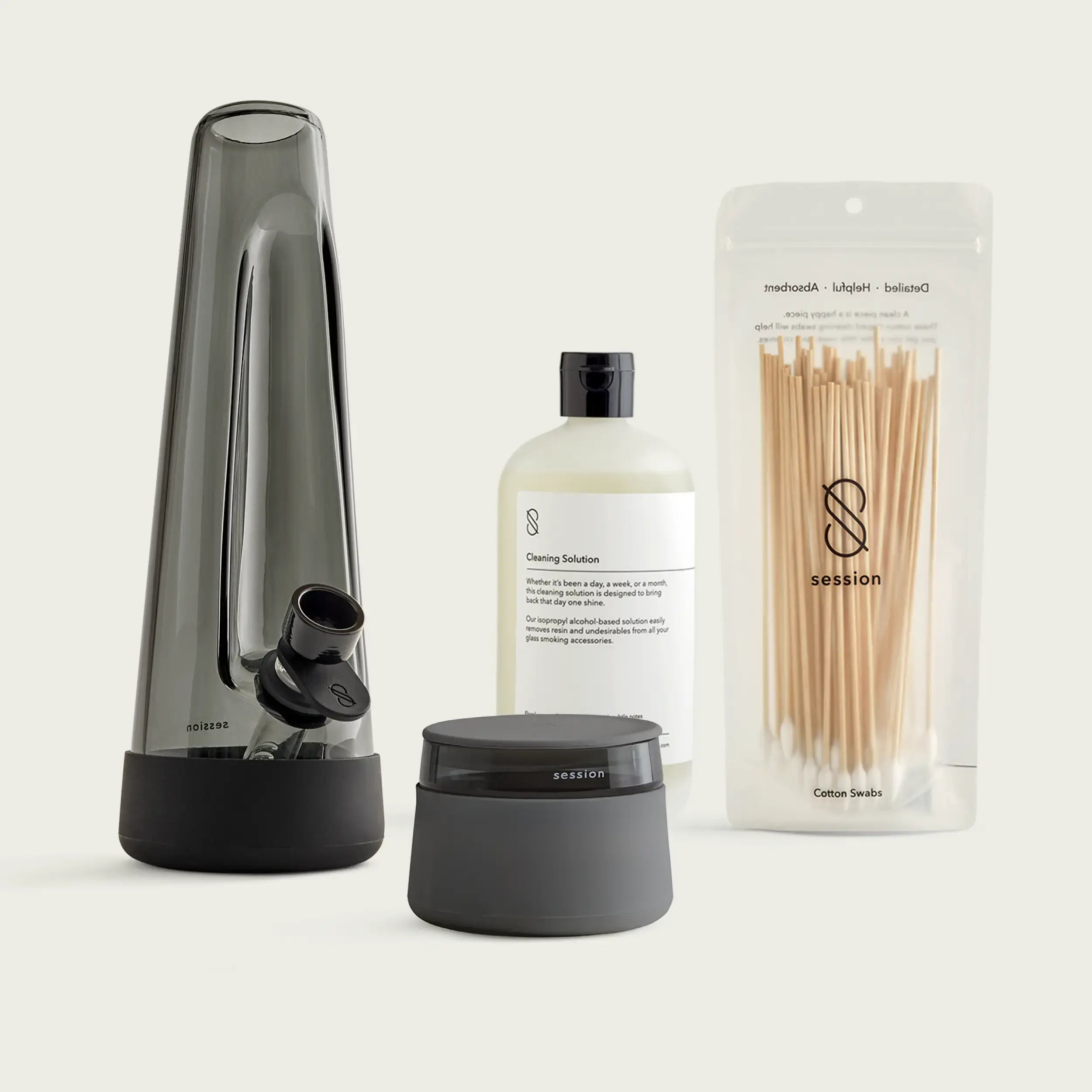 The Session Goods Starter Bundle, featuring a designer ash-colored glass bong with a black silicone base and downstem, a black metal grinder, and a  stash jar with a silicone smell proof lid, all set against a clean white background.