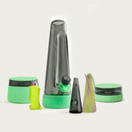 Complete Session Goods Ultimate Designer Glow Bundle including a smoky black glass bong, stash jar, low-profile ashtray, Aura pipe with protective sleeve, and a Toker Poker lighter case, all accented with glow-in-the-dark green silicone.