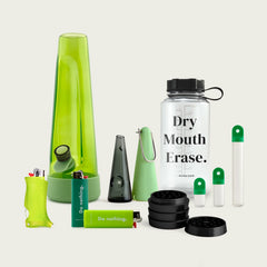 Session Goods Designer Series Ultimate Bundle in green tones, featuring a translucent green bong, matching silicone accessories, two ‘Do nothing.’ branded lighters, a clear water bottle labeled ‘Dry Mouth Erase.’, a sleek one-hitter pipe with cone sleeve, a black four-piece grinder, and two stash pods with green caps—all arranged on a neutral background.