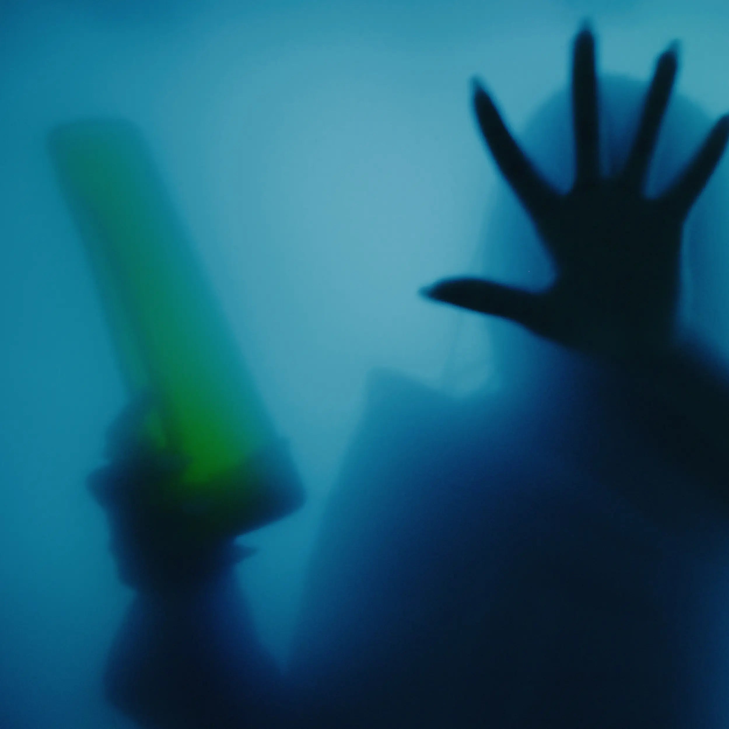 Designer Edition GLOW - model holding GLOW bong in hazed blue room with her other hand touching the glass