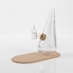 Session Goods ribbed clear glass dab rig with a sand tan silicone grommet and matching silicone mat, fitted with a clear quartz banger and carb cap.
