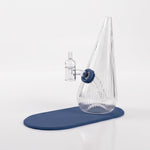 Session Goods ribbed clear glass dab rig with a slate blue silicone grommet and matching slate blue silicone mat, fitted with a clear quartz banger and carb cap.