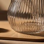 Close-up details of the Session Goods ribbed glass dab rig base resting on a silicone mat debossed with the "SESSION" logo.