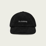 Black corduroy dad hat with ‘Do Nothing’ embroidered text on the front.