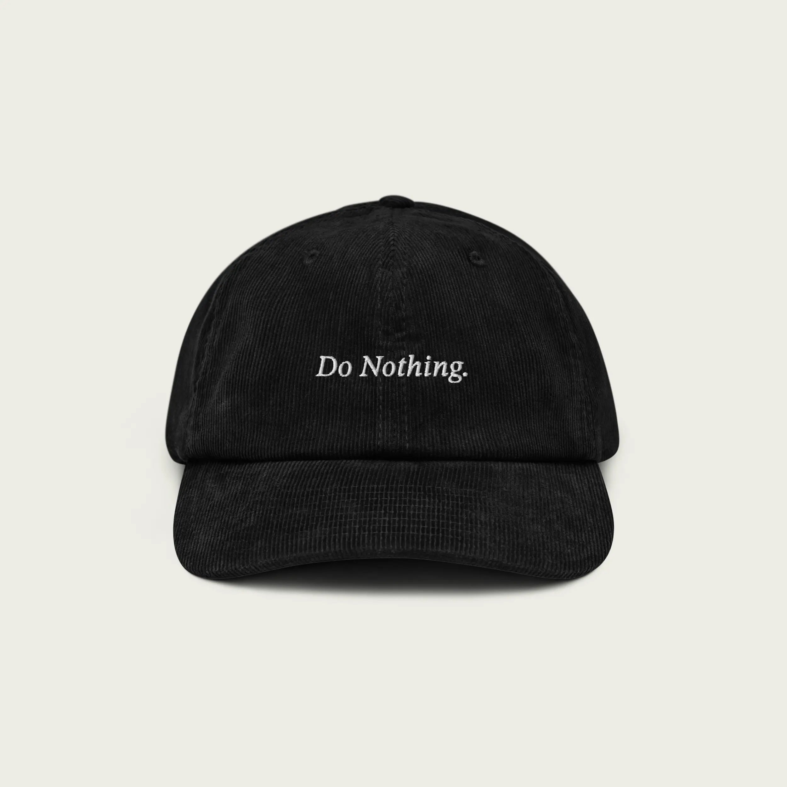 Black corduroy dad hat with ‘Do Nothing’ embroidered text on the front.