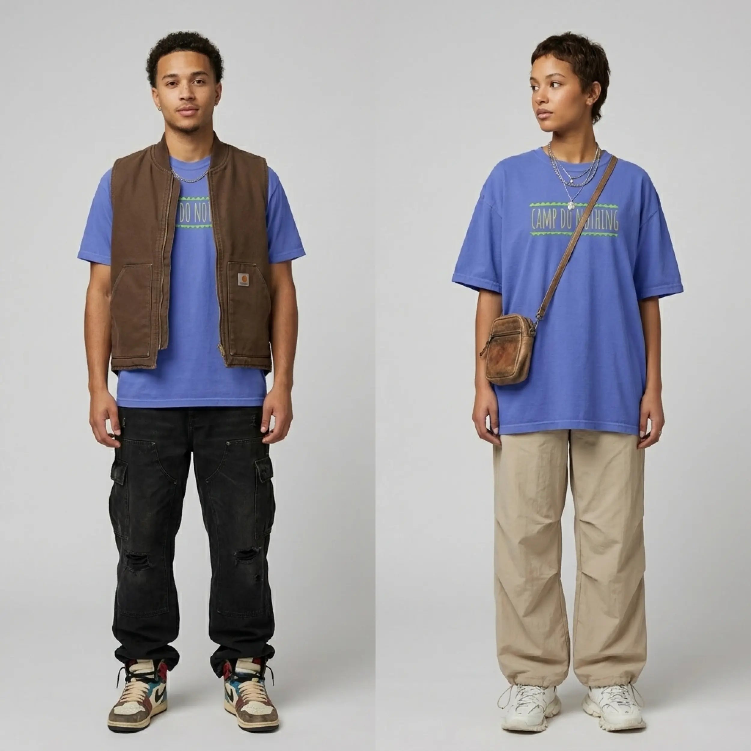 A studio shot of two models showcasing a blue graphic t-shirt against a plain white background. On the left, a young man wears the blue tee under a brown zip-up work vest, paired with distressed black cargo pants and multi-colored high-top sneakers. On the right, a young woman wears the same blue t-shirt featuring the neon green and yellow text "CAMP DO NOTHING", styled with loose beige pants, chunky white sneakers, layered silver necklaces, and a small brown leather crossbody bag.