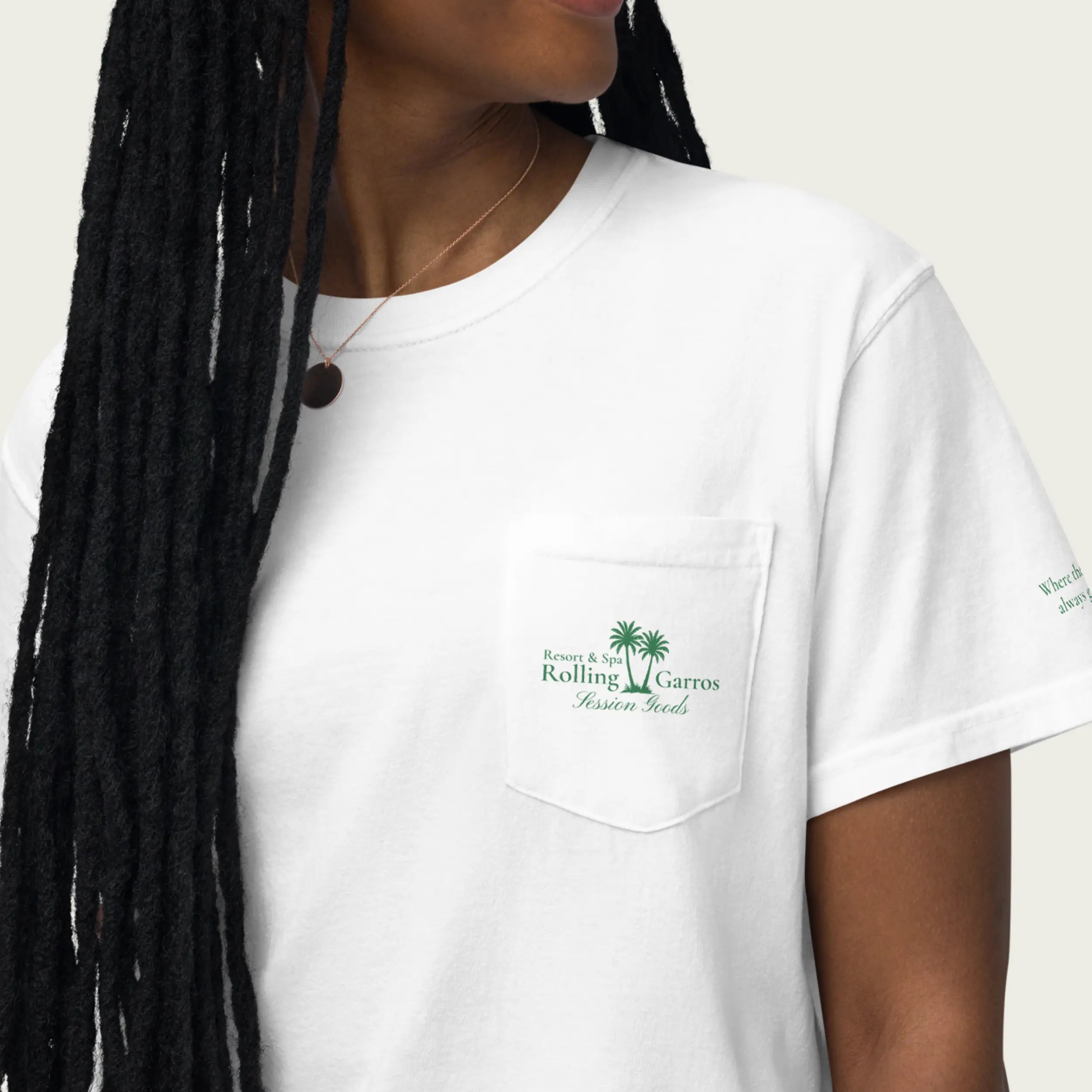 Model wearing white Session Goods Rolling Garros club t-shirt with front pocket green palm tree logo and sleeve text.